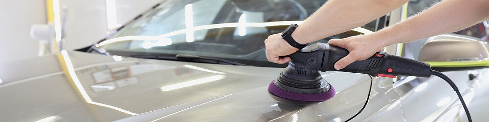 Worker With Orbital Polisher In Auto Repair Shop Closeup